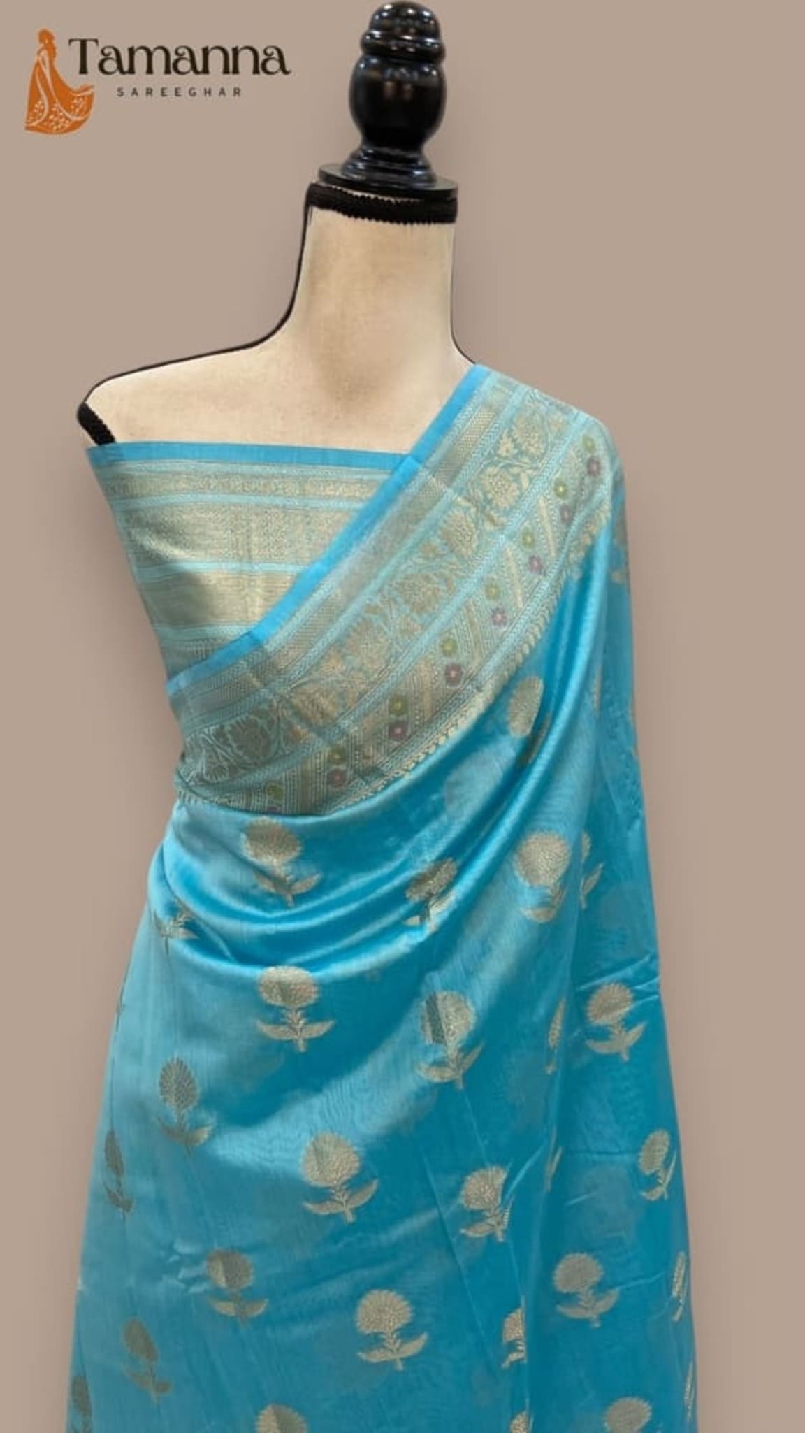 Sky blue cotton Banarasi saree draped on mannequin, gold border and bird motifs