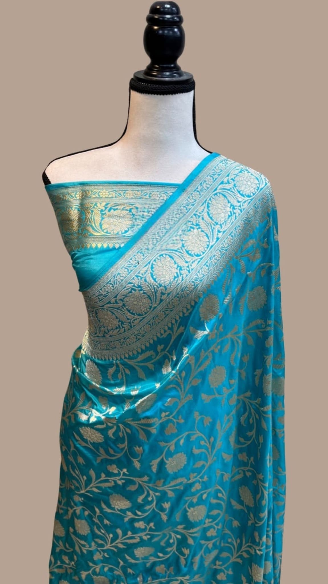 Teal blue silk saree with gold jaal motifs and contrast pallu, draped on mannequin