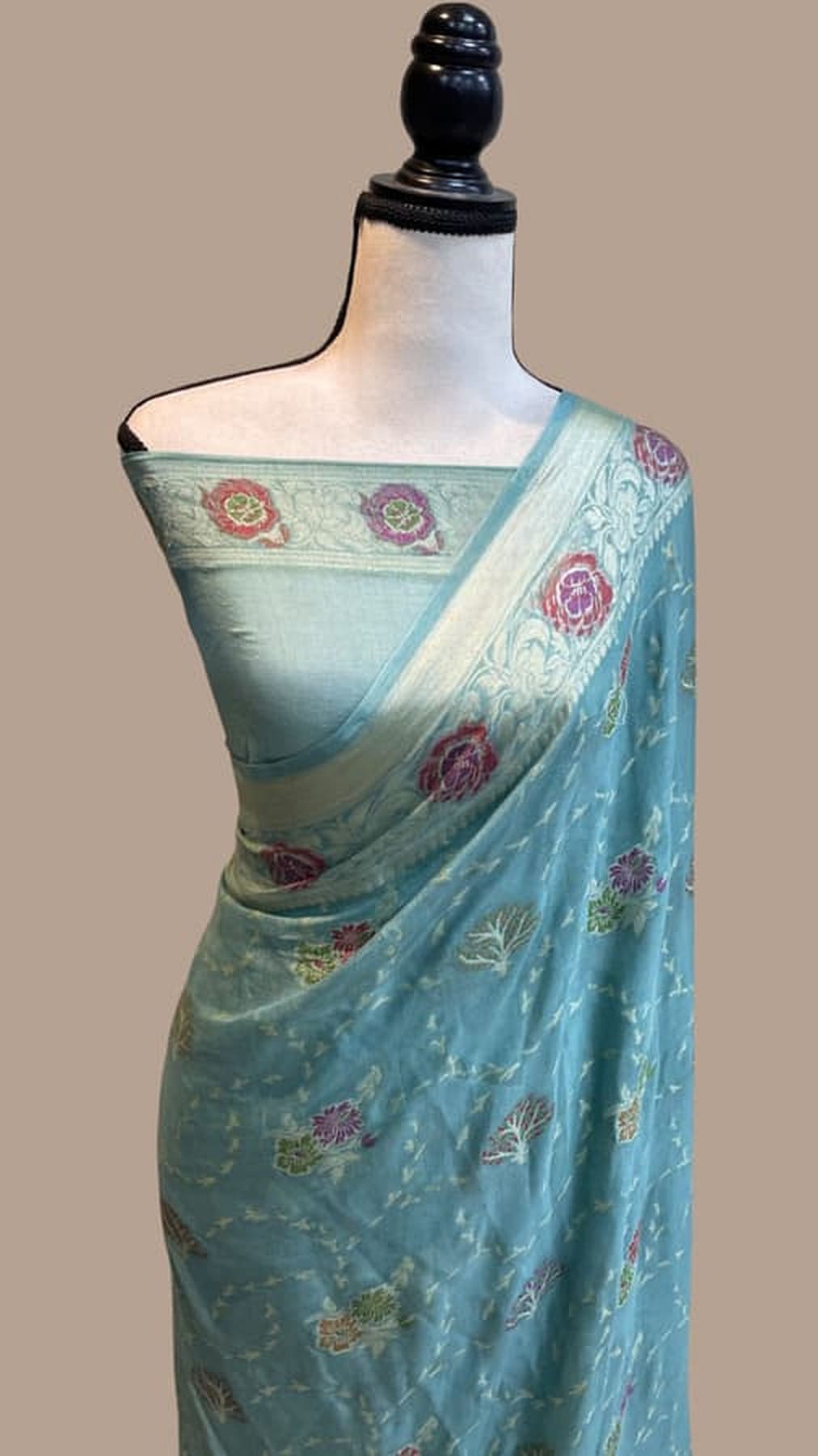 Sky blue chiffon saree with pink floral motifs and zari pallu border