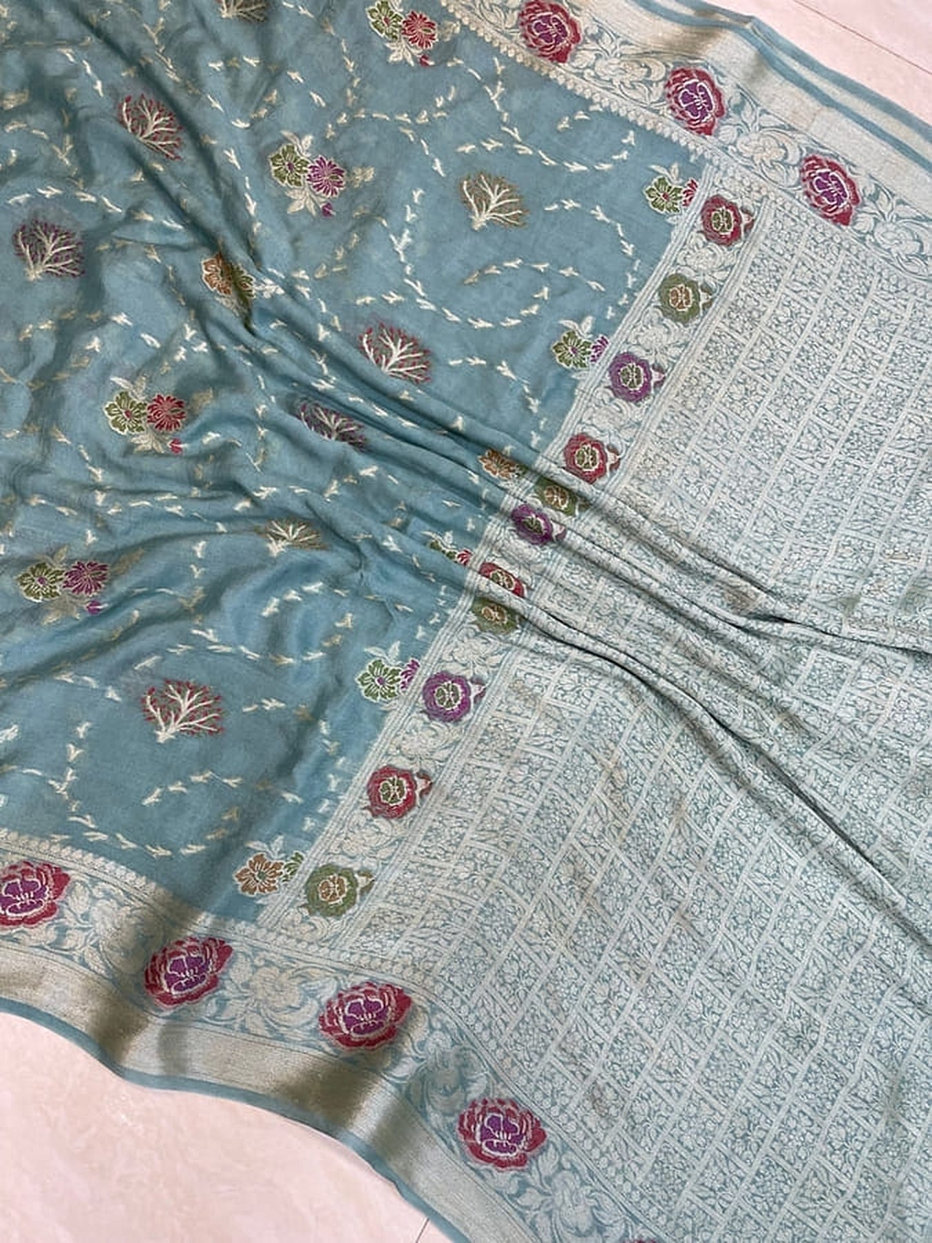 Sky blue chiffon saree close-up with floral motifs and detailed woven border panel
