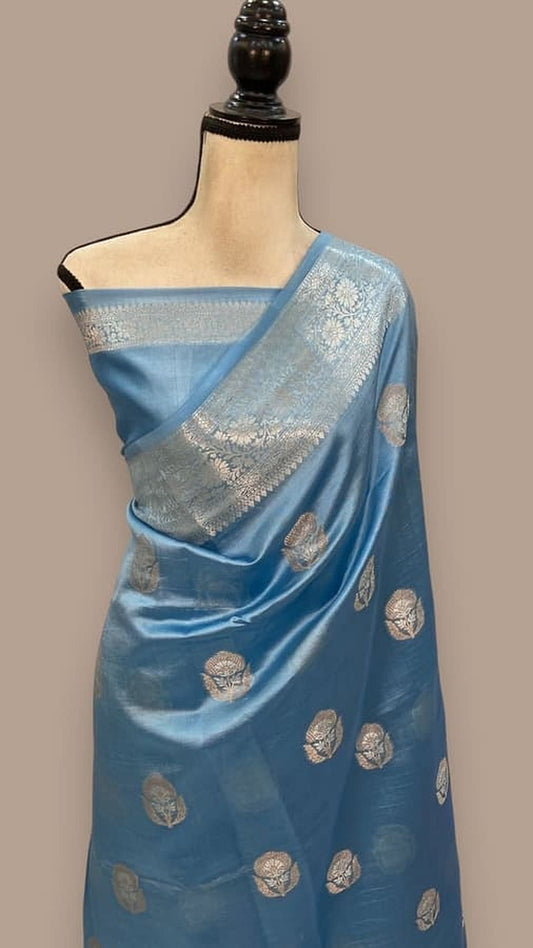 Sky blue silk saree with zari pallu border and scattered gold leaf motifs, draped on mannequin