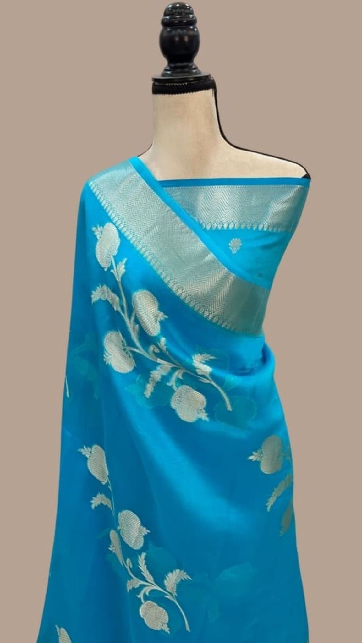 Sky blue Banarasi saree with gold pallu panel and off-white floral motifs, draped