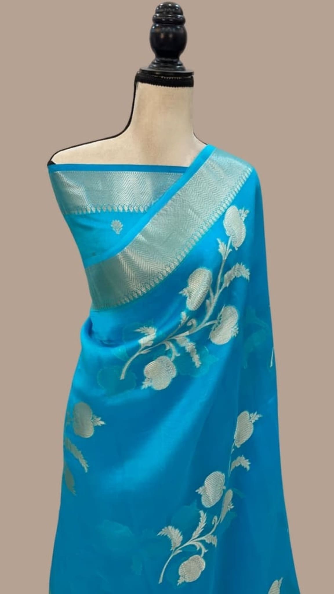 Sky blue Banarasi saree with gold border and off-white floral motifs on drape