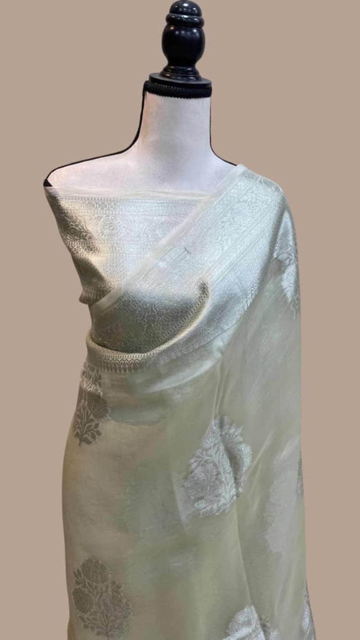 Smoky white handloom Banarasi saree with gold border and floral motifs on pallu