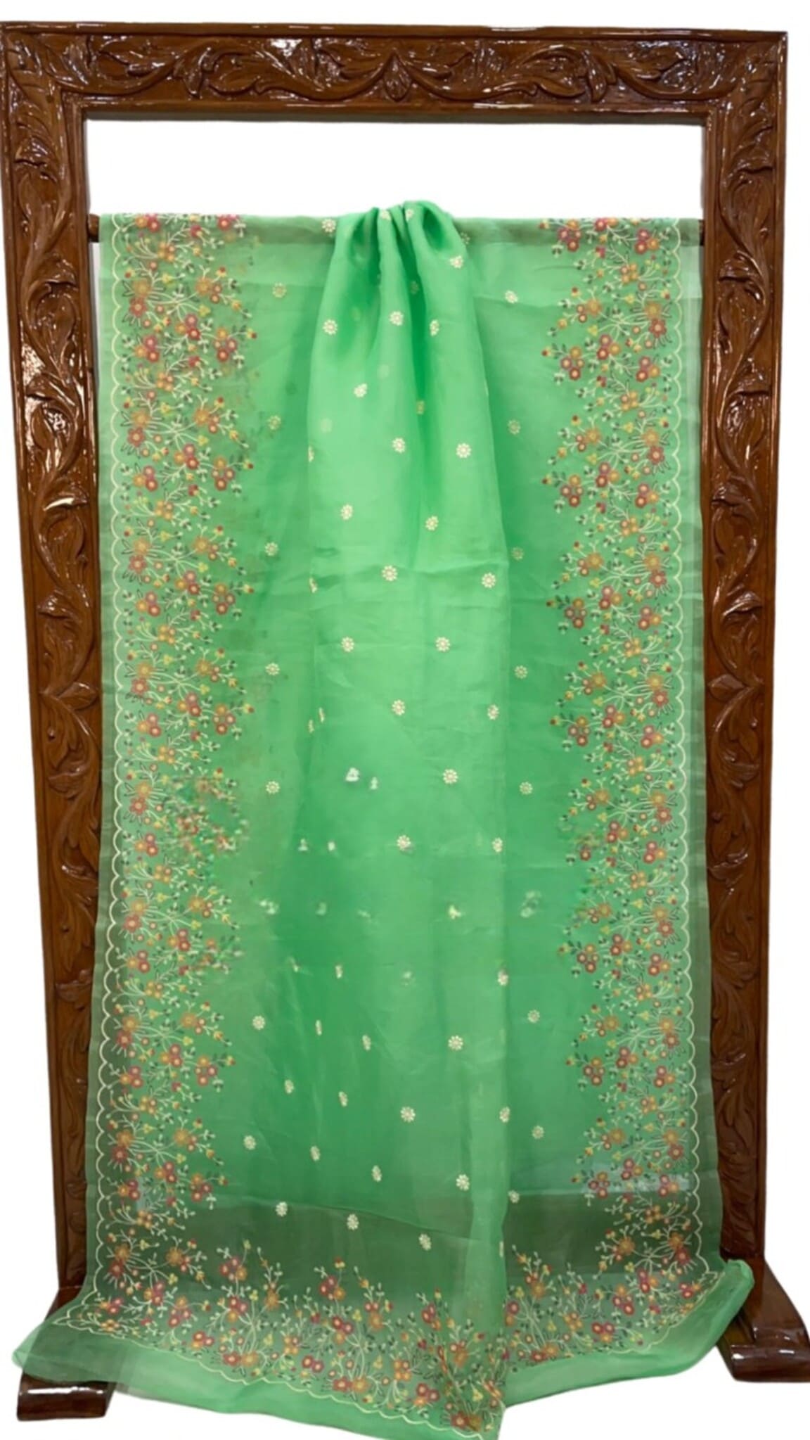 Green organza saree folded display with floral lace border and small motif work