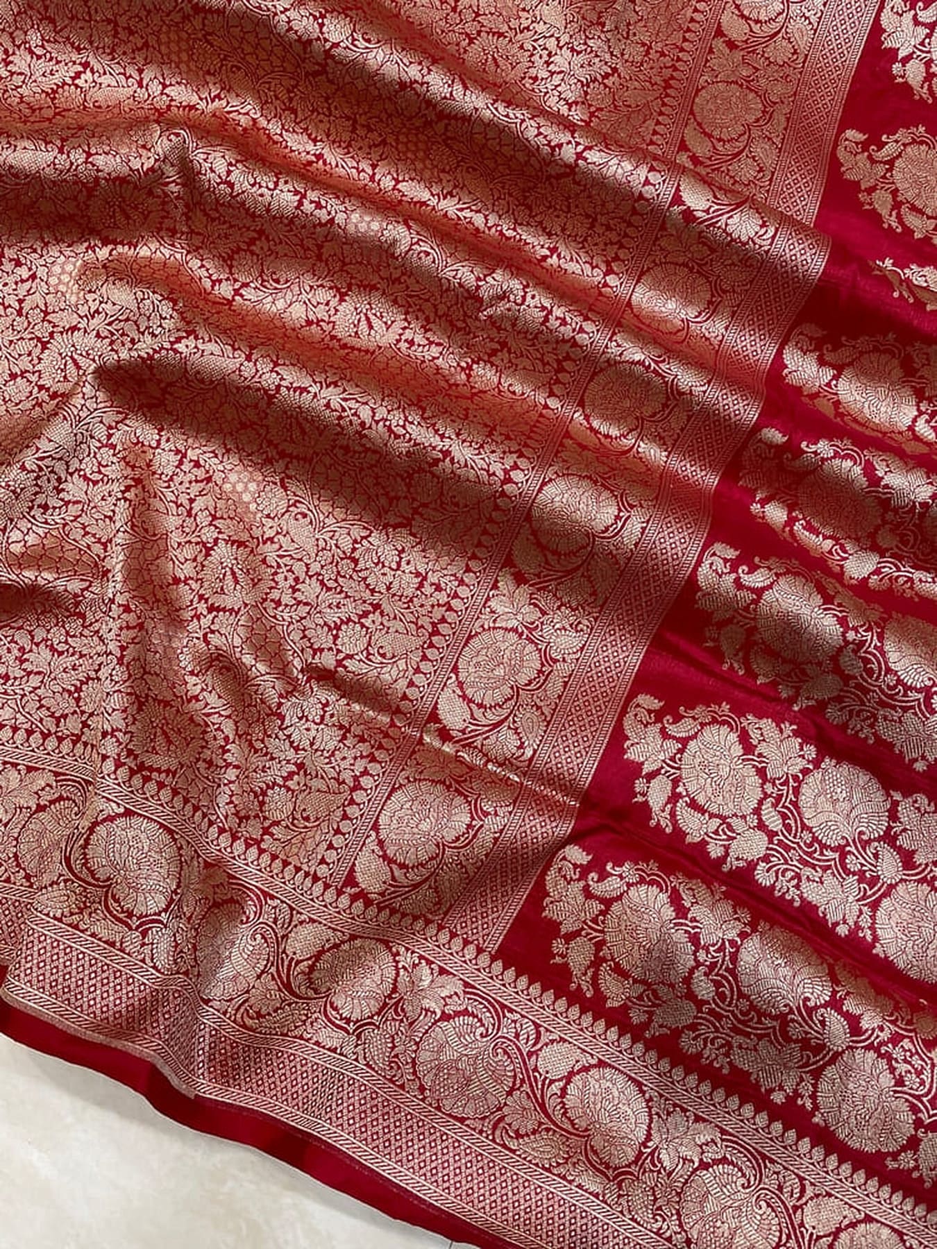 Banarasi saree pallu border detail with ornate circular motifs in red on maroon