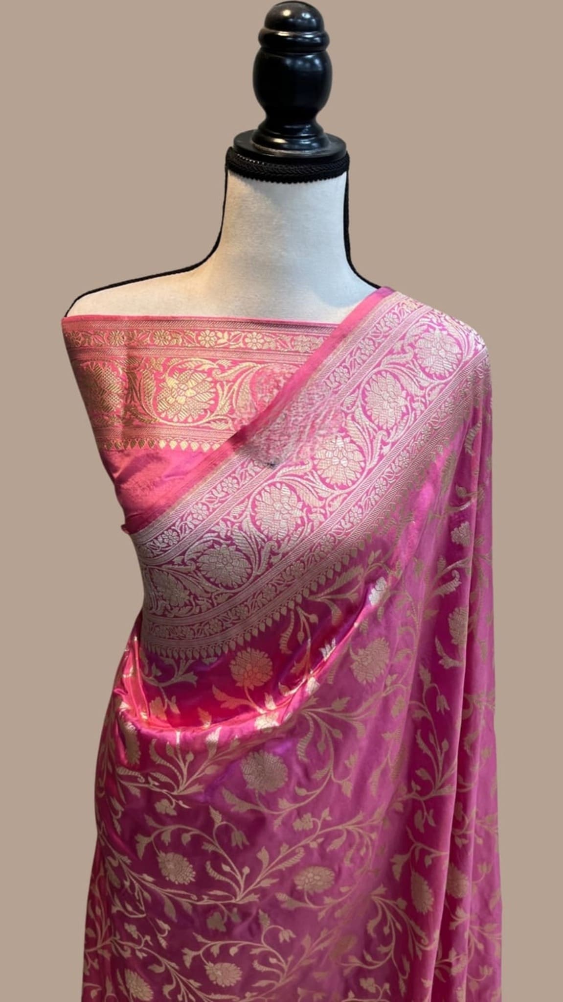 Banarasi silk saree on mannequin, magenta floral motifs with wide pink-gold zari border