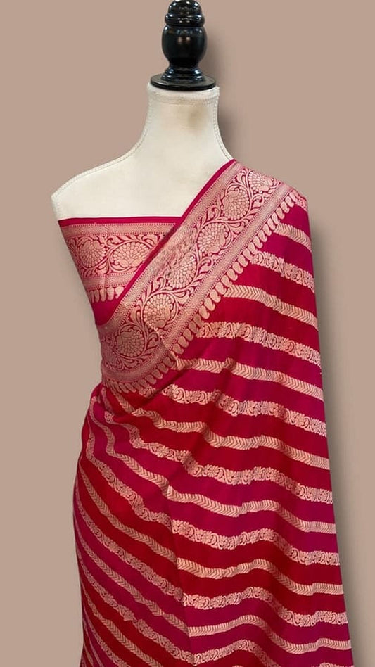 Tomato red Banarasi chiffon saree draped over mannequin shoulder, gold border and stripes