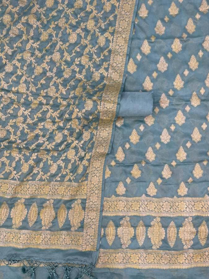 Teal-blue and gold chiffon dress material with zari pattern panels and decorative border