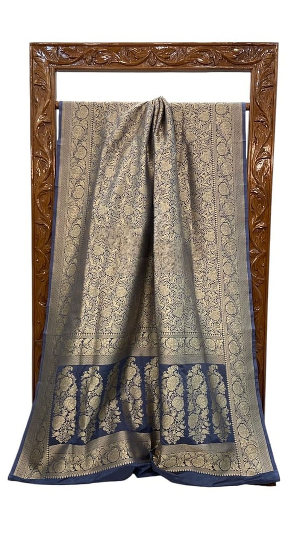 Banarasi silk saree laid flat with beige body, circular motifs, and wide blue border