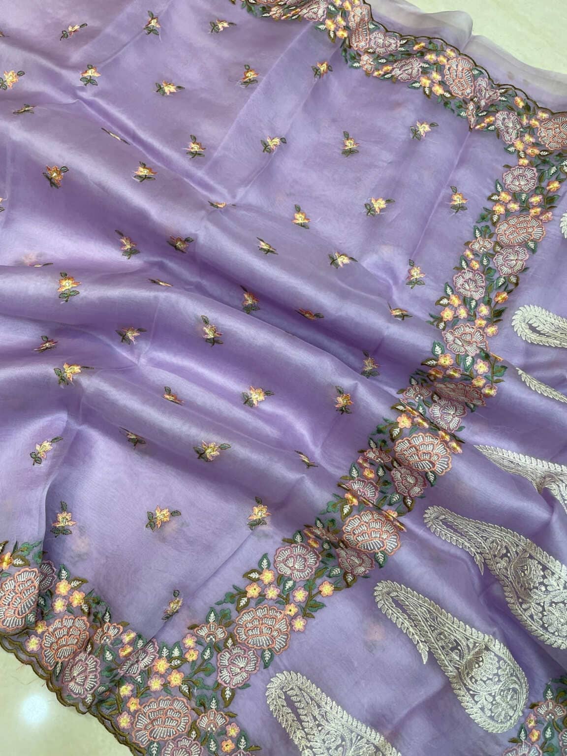 Lilac organza saree close-up with scattered gold sprig motifs and ornate green border