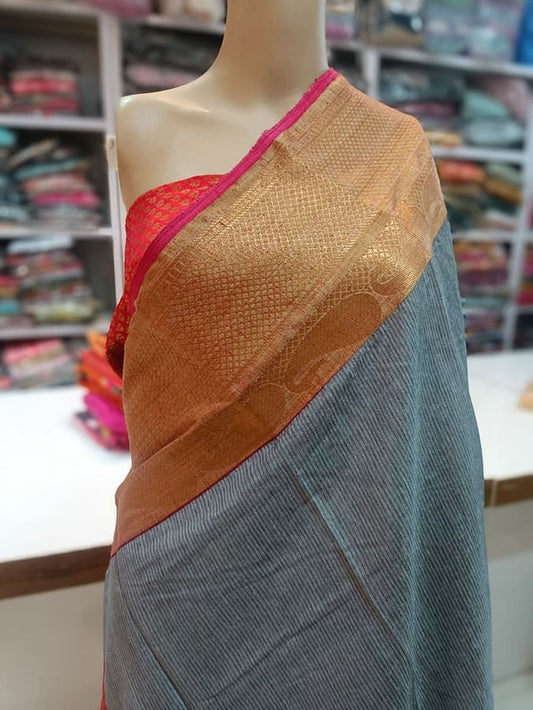 Turquoise gray silk saree with copper-gold pallu and red border on mannequin
