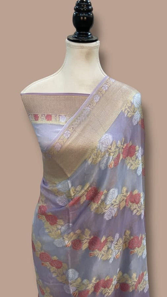 Light blue chiffon saree with pastel floral print and gold border, pallu shown on mannequin