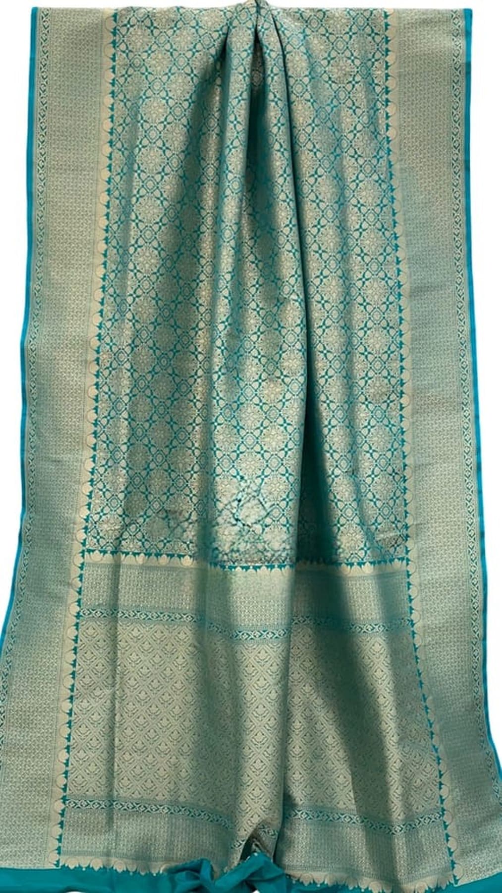 Teal silk saree folded view with geometric motif panels and gold-trim border