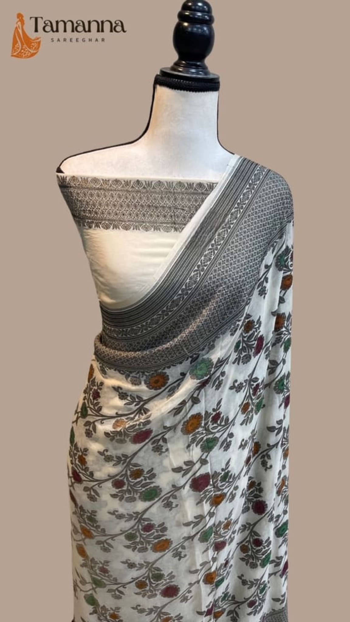 White floral Banarasi handloom saree with dark zari border, shown on mannequin