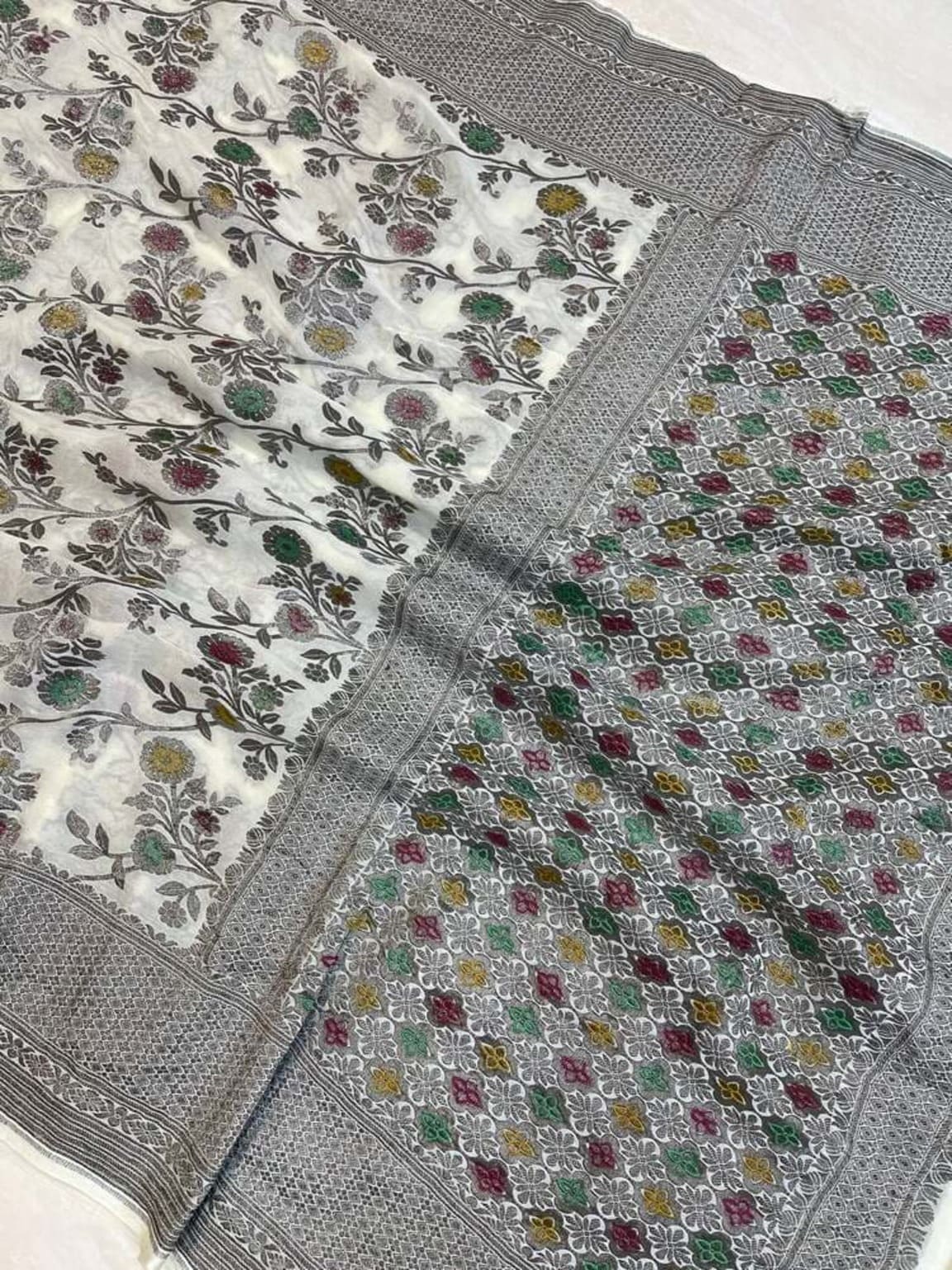 White floral saree close-up with gray zari border and multicolor flower vine pattern