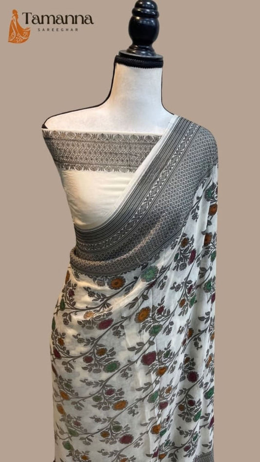 White saree on mannequin with black zari pallu border and floral body print