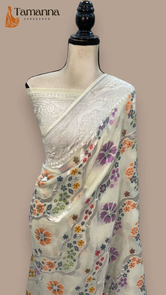 White saree on mannequin with multicolor floral motifs on pallu and body