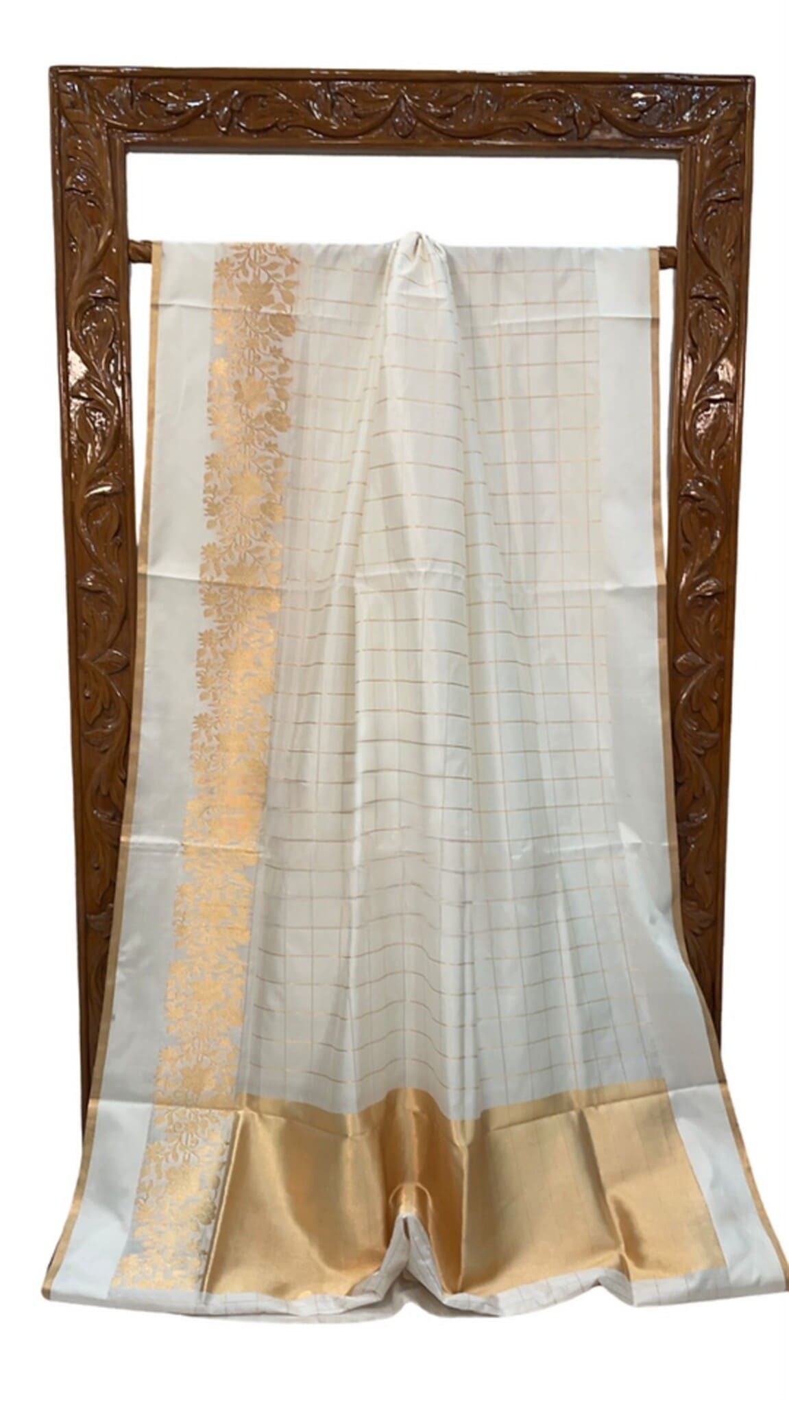 White silk saree on display frame, gold edge border and light geometric pattern