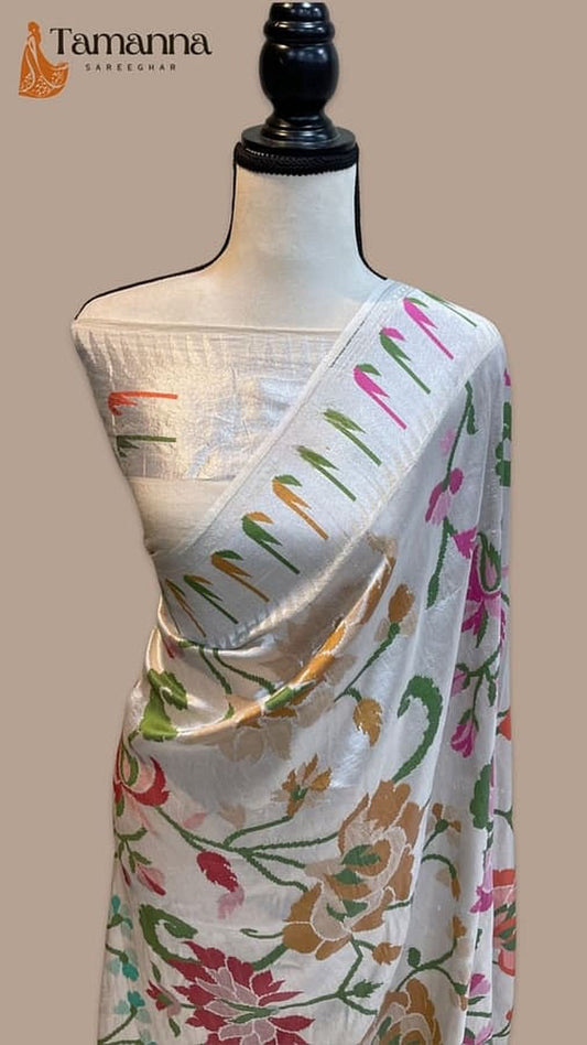 White Banarasi saree on mannequin with floral vine accents and pallu border