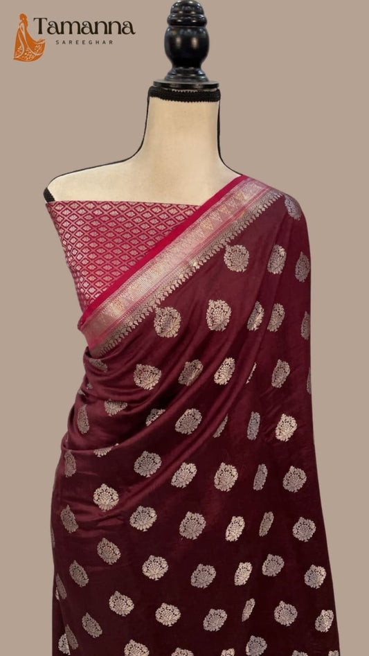 Wine maroon silk saree draped on mannequin, gold motifs and pink-gold zari border