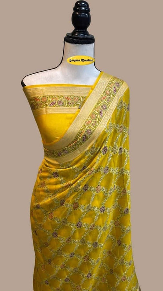 Yellow chiffon saree draped on mannequin with gold border and all-over motifs