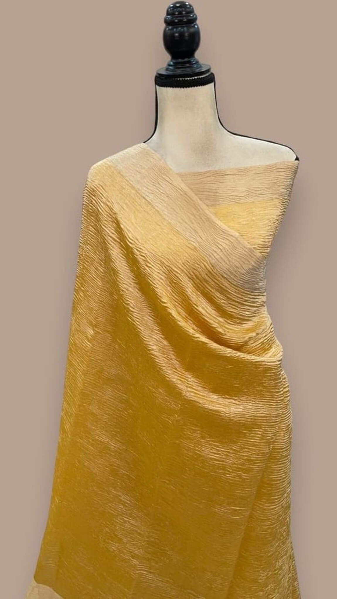 Yellow tissue crush handloom saree draped with pallu over shoulder on mannequin